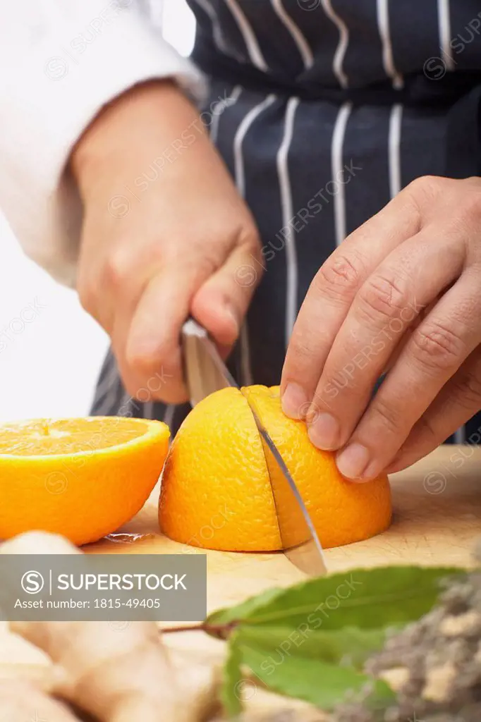 Person cutting an orange in quarters, close_up