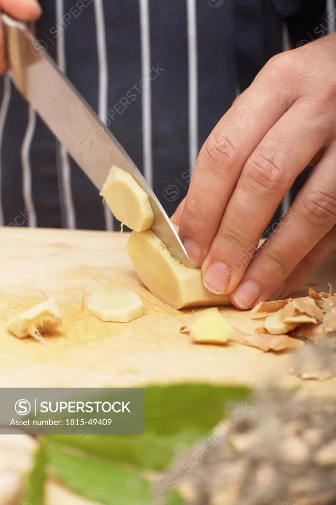 Person slicing ginger root, close_up