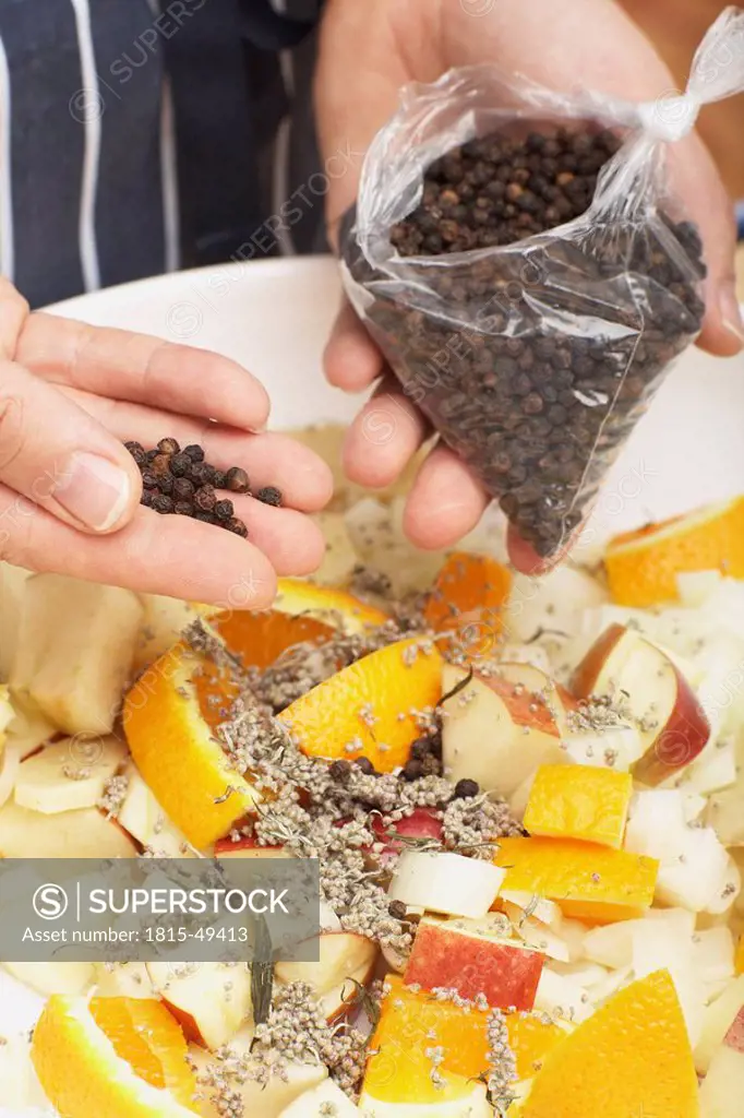 Person flavouring the stuffing with peppercorns, close_up