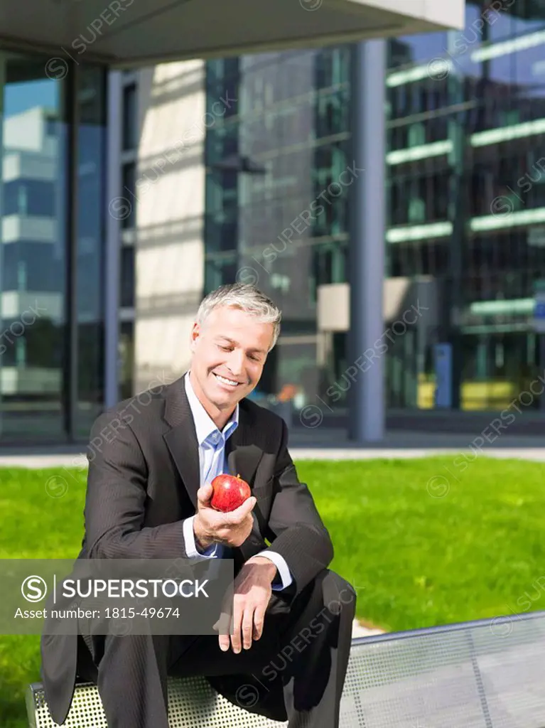 Germany, Baden_Württemberg, Stuttgart, Businessman holding an apple