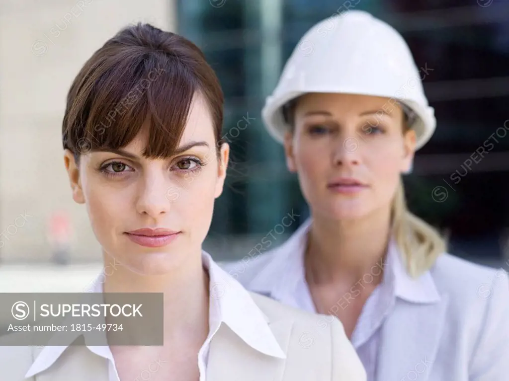 Germany, Baden_Württemberg, Stuttgart, Two businesswomen, one with hard hat, portrait