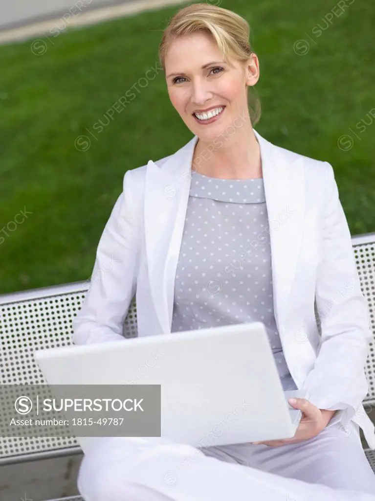 Germany, Baden_Württemberg, Stuttgart, Businesswoman using laptop out of doors