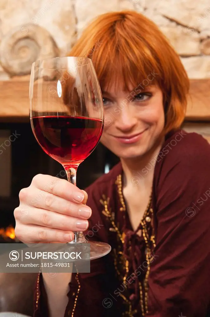 Woman holding a glass of red wine, portrait, close_up