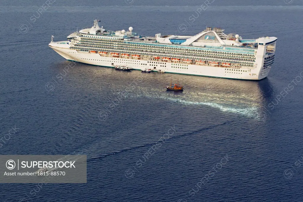 Europe, Greece, Thira, Cyclades, Santorini, View of cruise liner with small boats in aegean sea