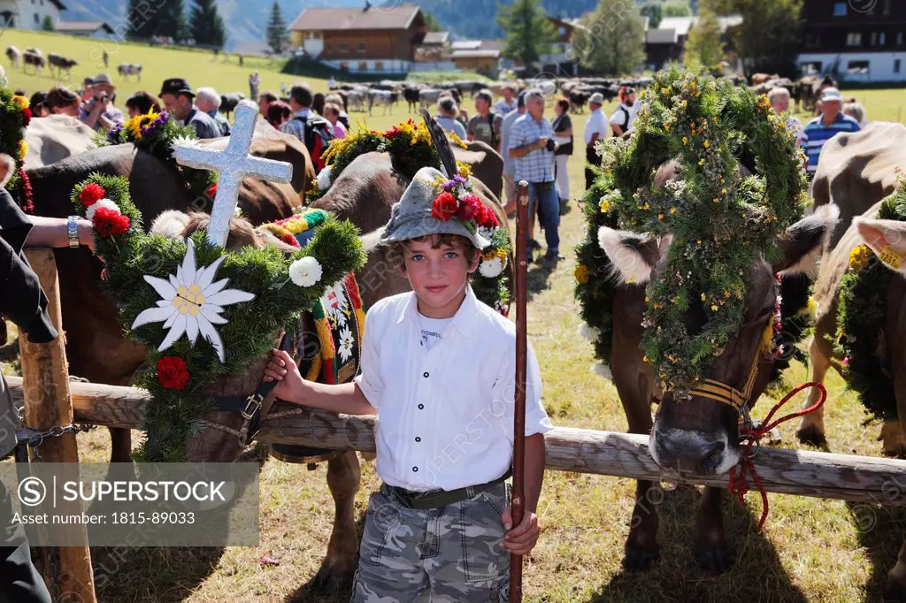 Austria, Tyrol, Tannheim, Almabtrieb, Boy holding decorated cow