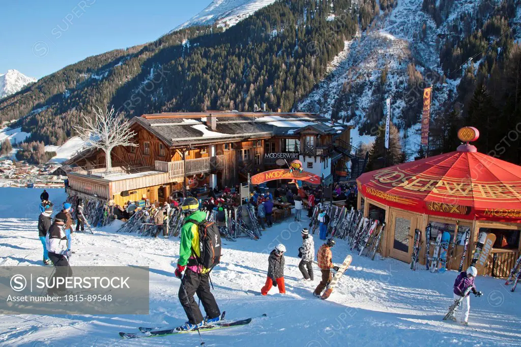 Austria, Tyrol, St. Anton am Arlberg, Mooserwirt, People skiing near ski hut in winter