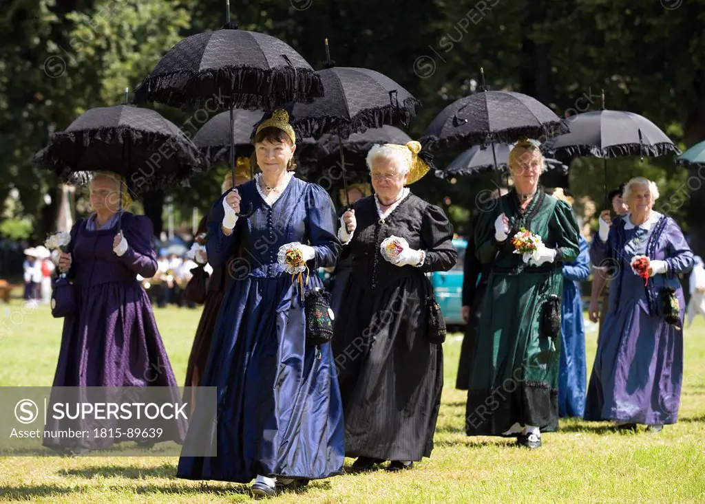 Austria, Salzkammergut, Mondsee, Women in traditional costume with umbrella