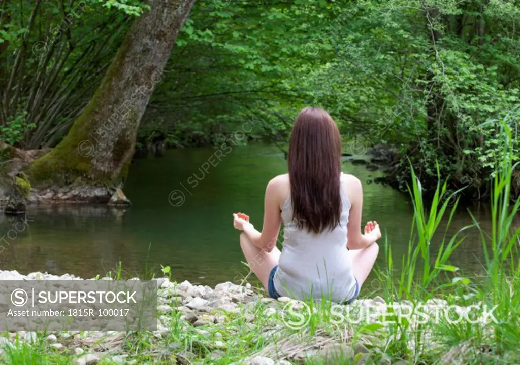 Austria, Young woman doing meditation