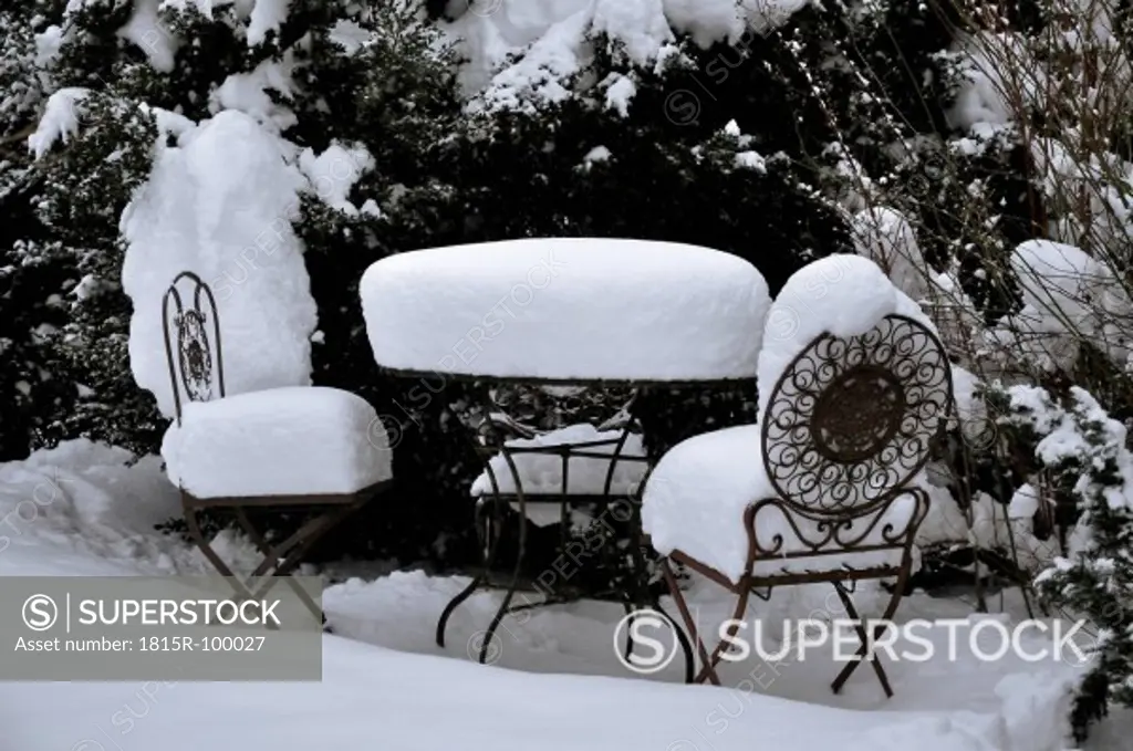 Germany, View of garden table and chair covered with snow