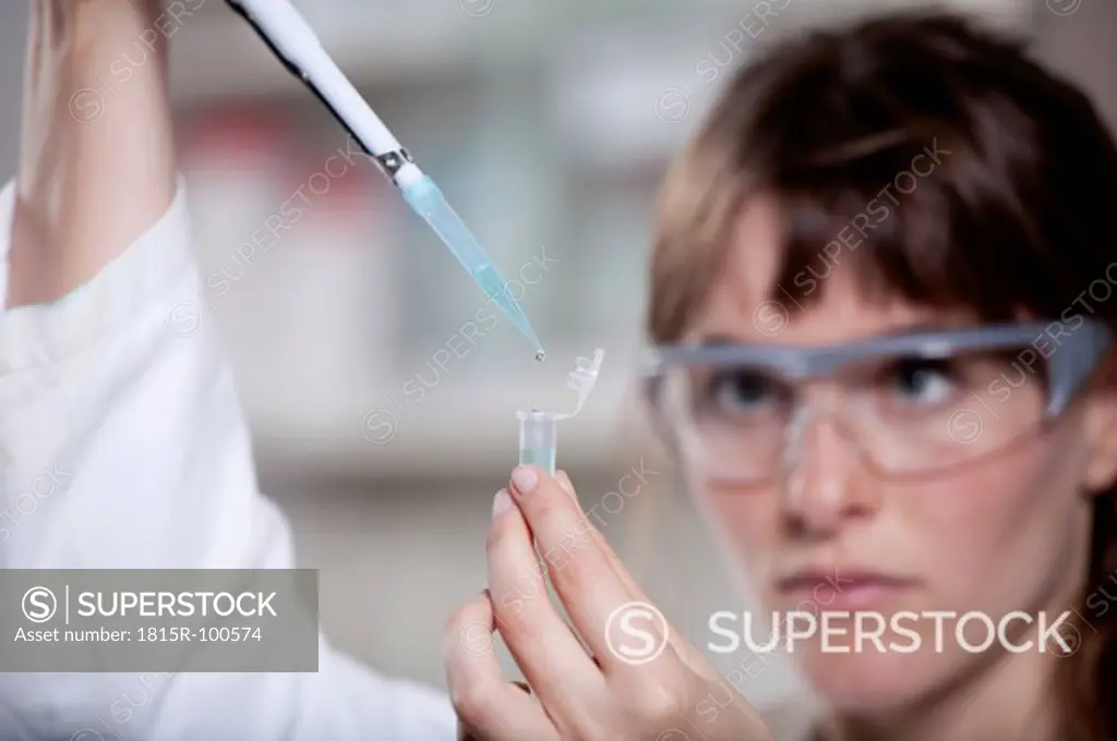 Germany, Bavaria, Munich, Scientist with pipette and test tube in laboratory