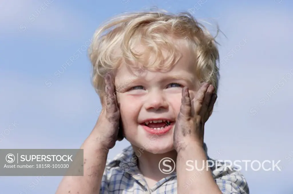 Germany, Bavaria, Boy playing with charcoal, smiling