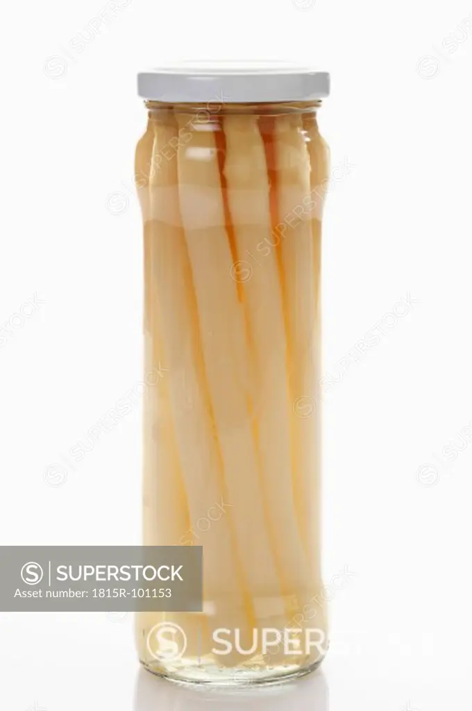 Preserved asparagus in glass jar on white background