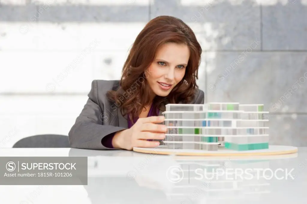 Germany, Leipzig, Businesswoman looking at architectural model