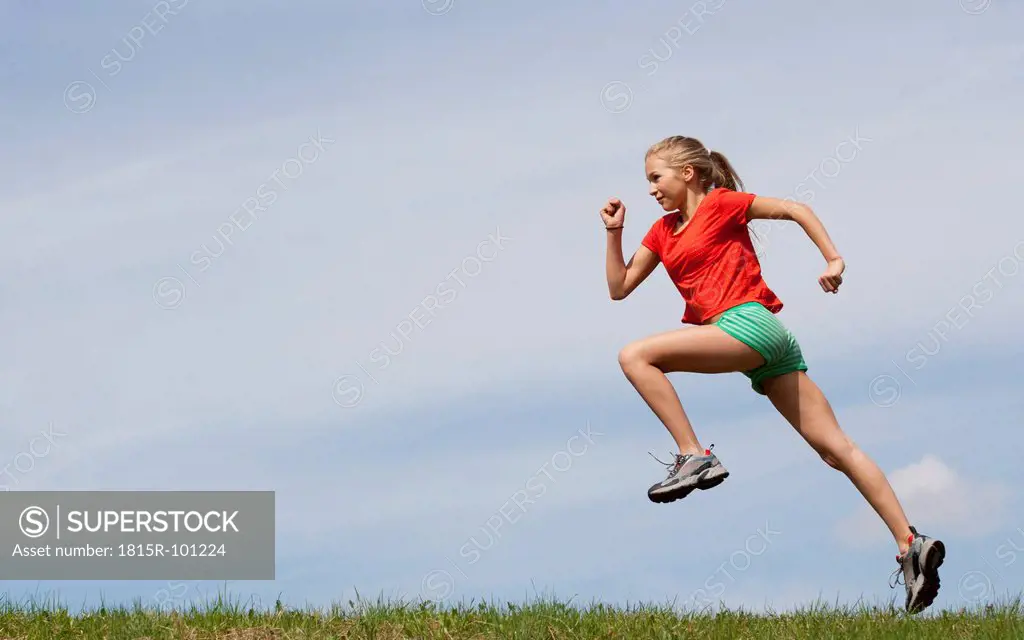 Austria, Teenage girl running on grass