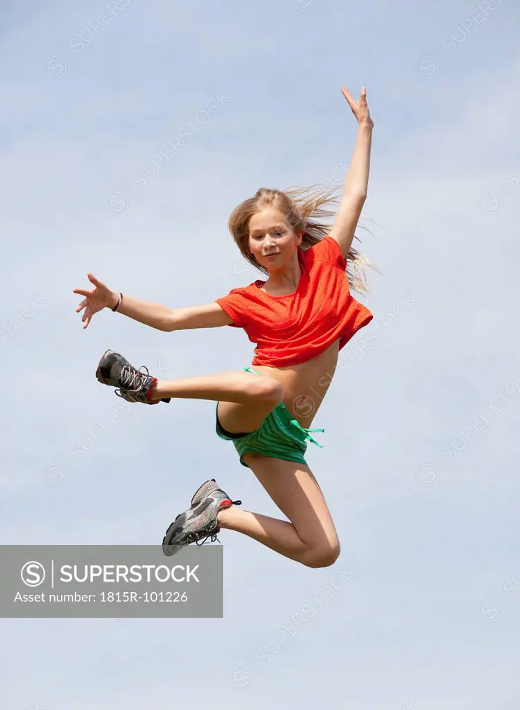 Austria, Teenage girl jumping against sky