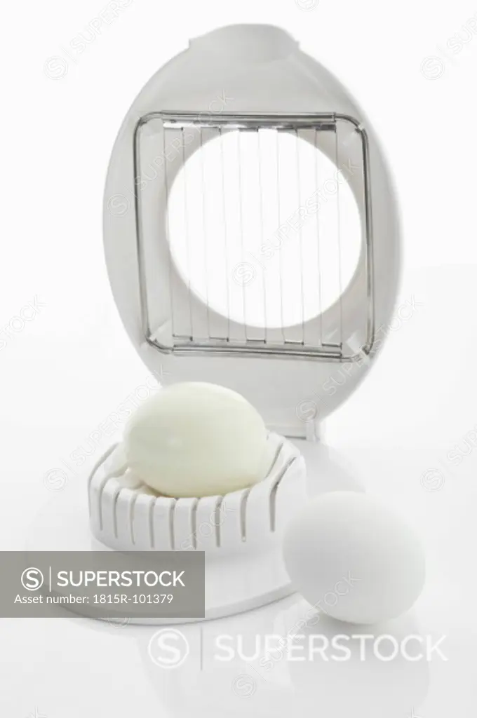 Egg cutter with egg on white background