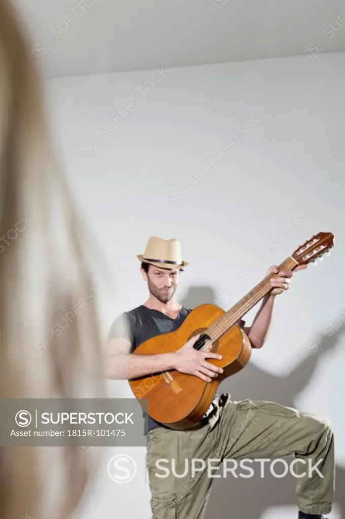 Man plucking guitar, smiling