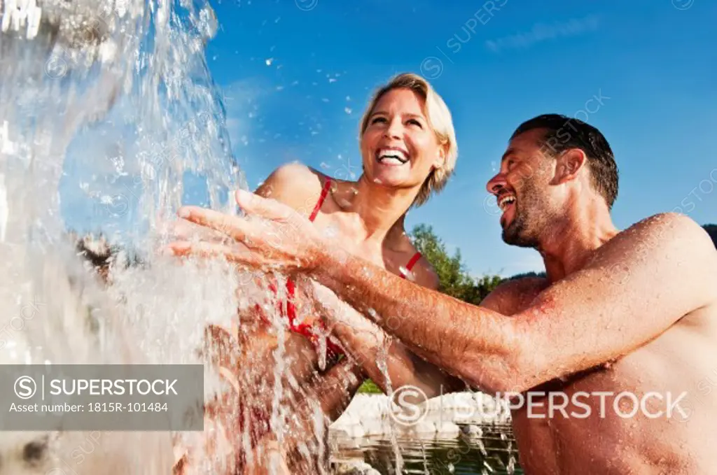 Austria, Salzburg County, Couple standing under waterfall