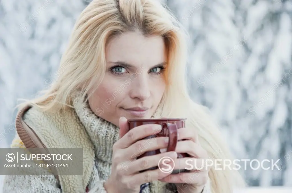 Austria, Salzburg County, Mid adult woman drinking tea, smiling