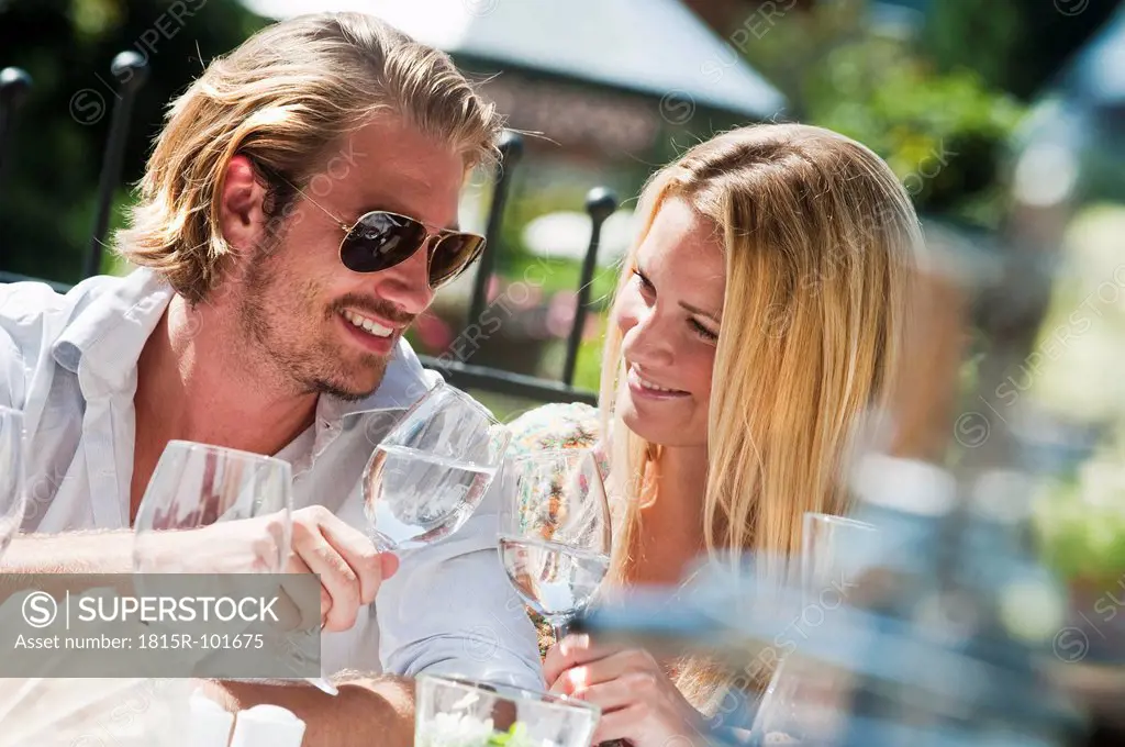 Austria, Salzburg County, Couple sitting on terrace in hotel garden