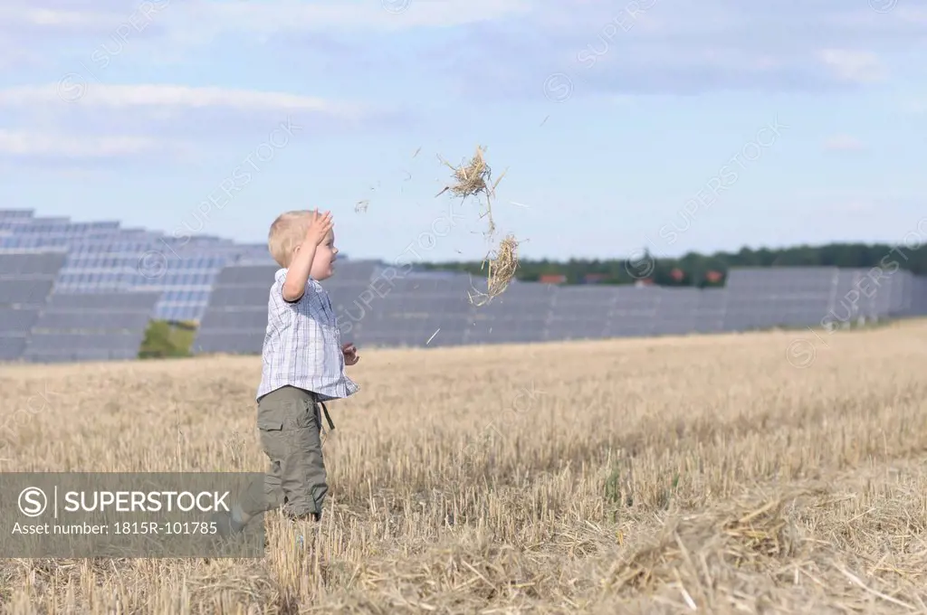 Germany, Saxony, Boy running in grass, solar panels in background