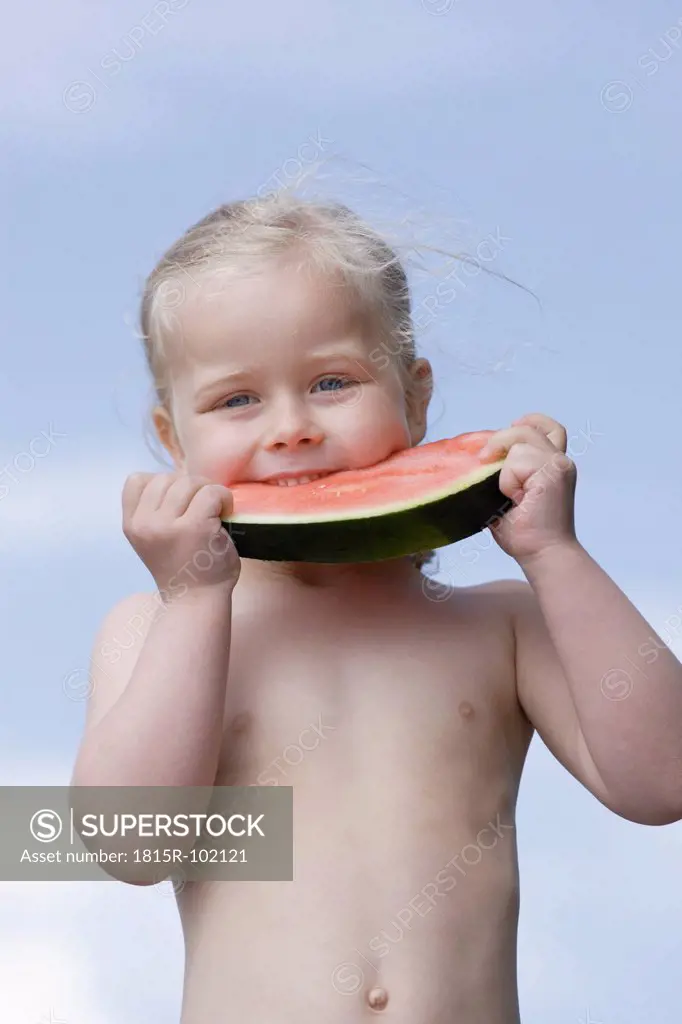 Germany, Bavaria, Girl eating piece of watermelon