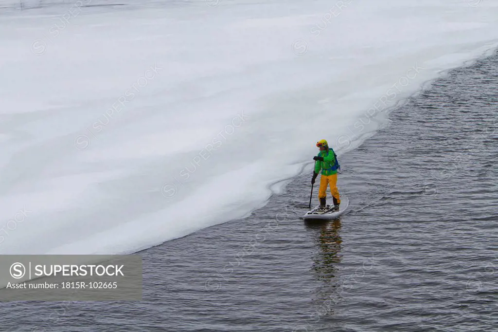 Norway, Narvik, Mature man paddling in polar ocean