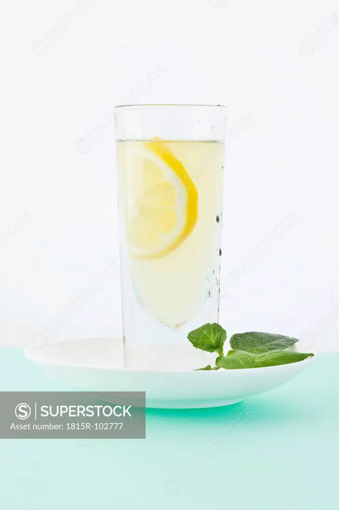 Lemonade with mint, sage and honey on coloured background