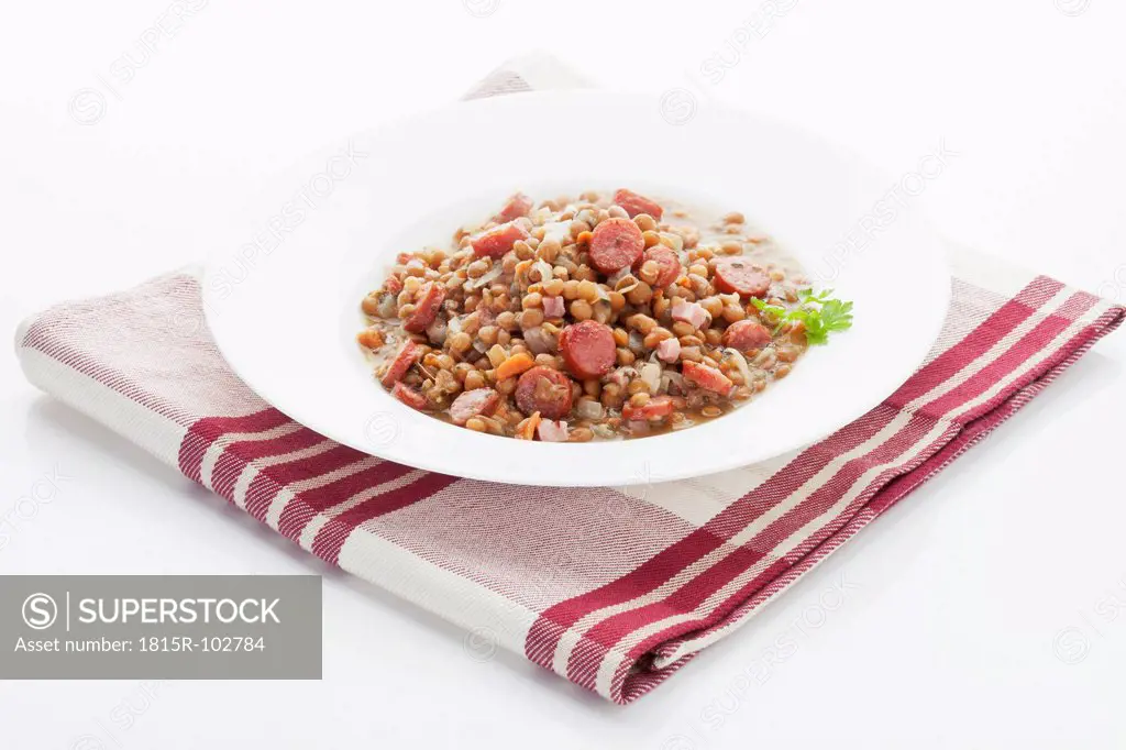 Lentil with sausage in plate on napkin