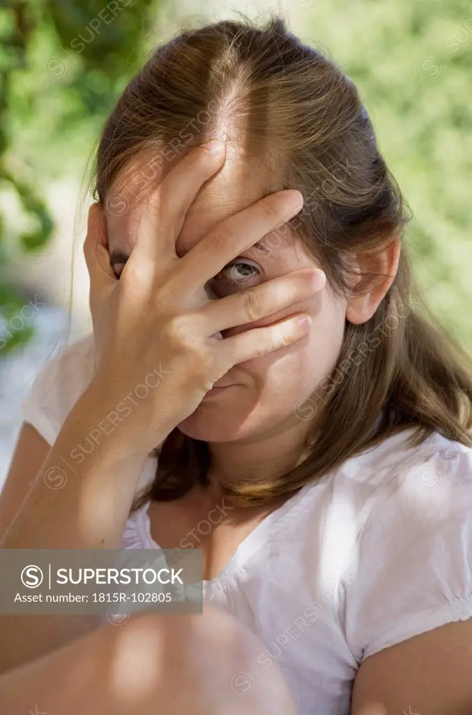 Greece, Mid adult woman covering her face with hand