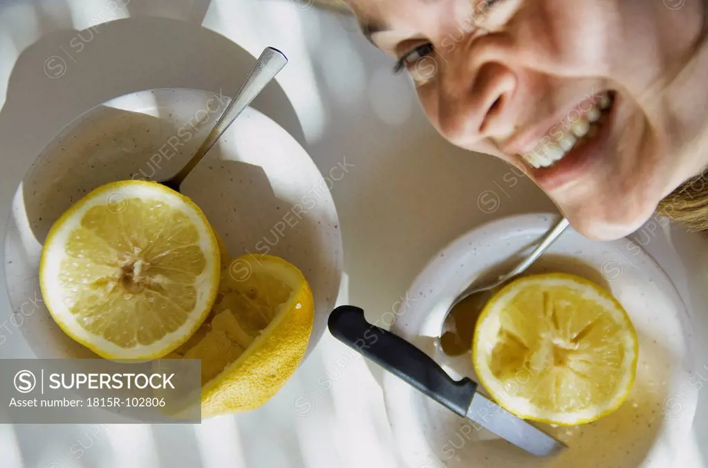 Greece, Mid adult woman with grapefruit in plate on table