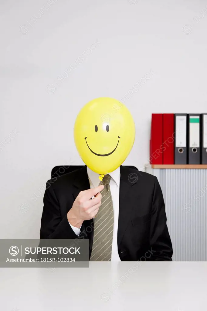 Germany, Businessman with smiley face balloon