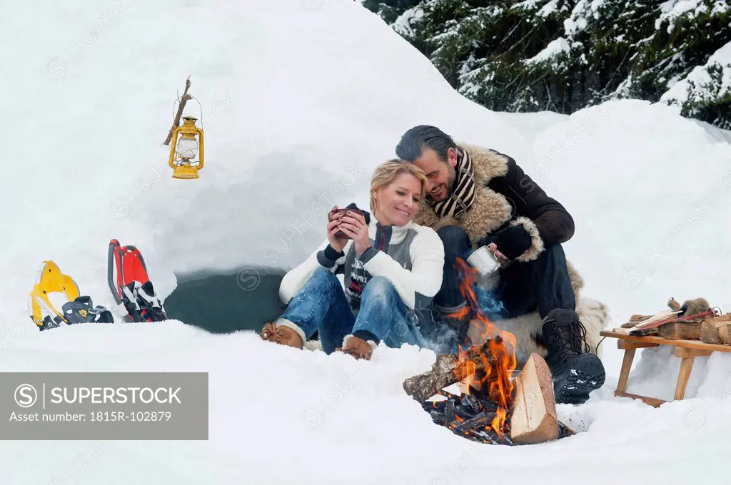 Austria, Salzburg County, Couple sitting near fireplace