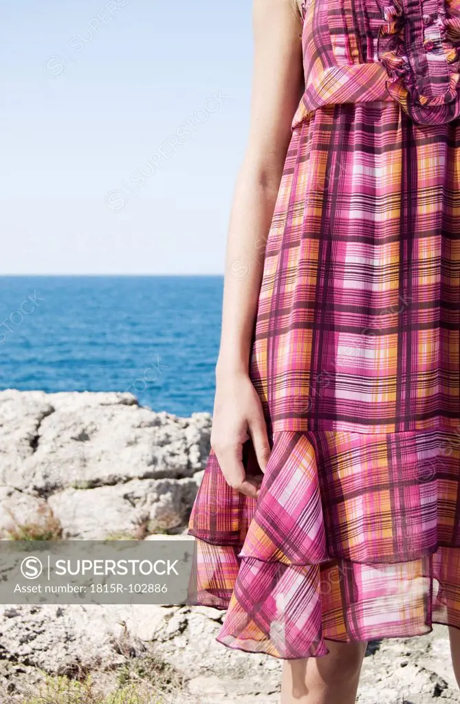 Spain, Mallorca, Young woman standing with sea in background