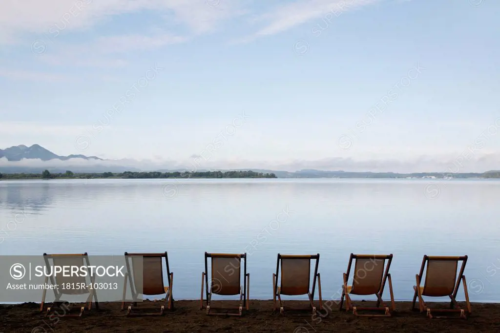 Germany, Bavaria, Chiemsee, Row of folded chairs by lake