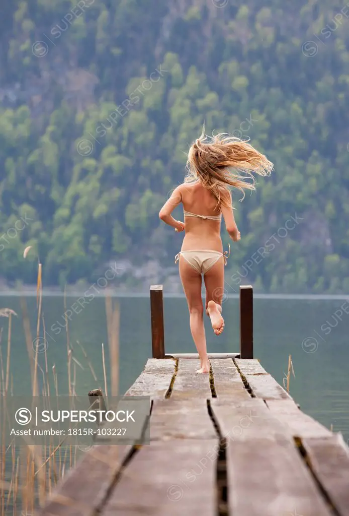 Austria, Teenage girl running on jetty