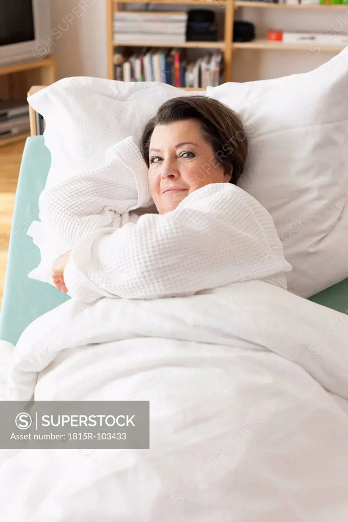 Germany, Leipzig, Senior woman relaxing on medical bed