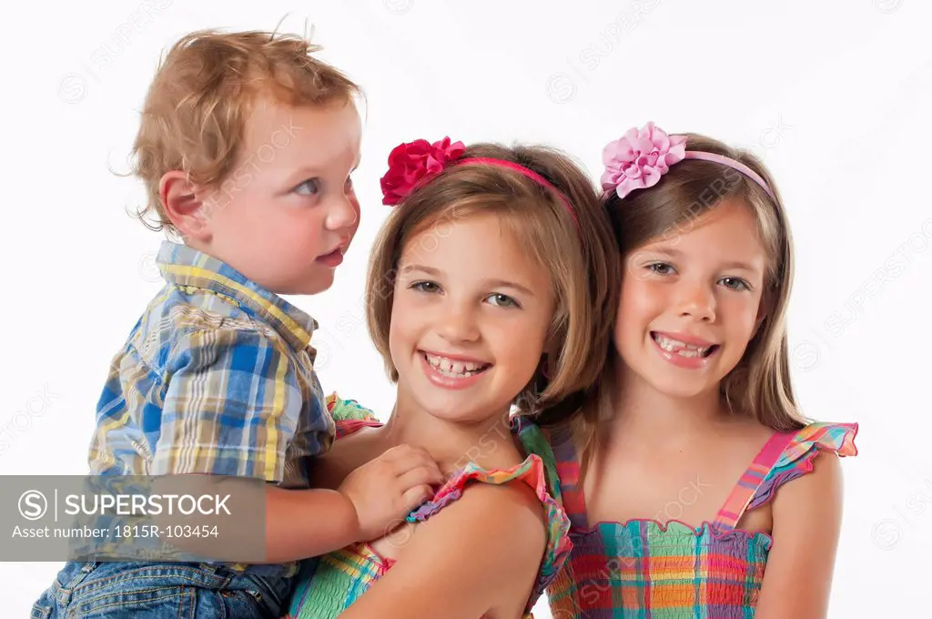 Boy and girl smiling against white background, portrait