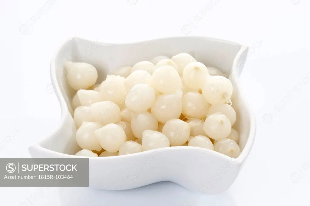 Silverskin onions in bowl on white background