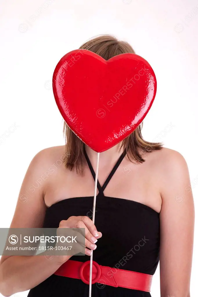 Young woman holding heart in front of her head