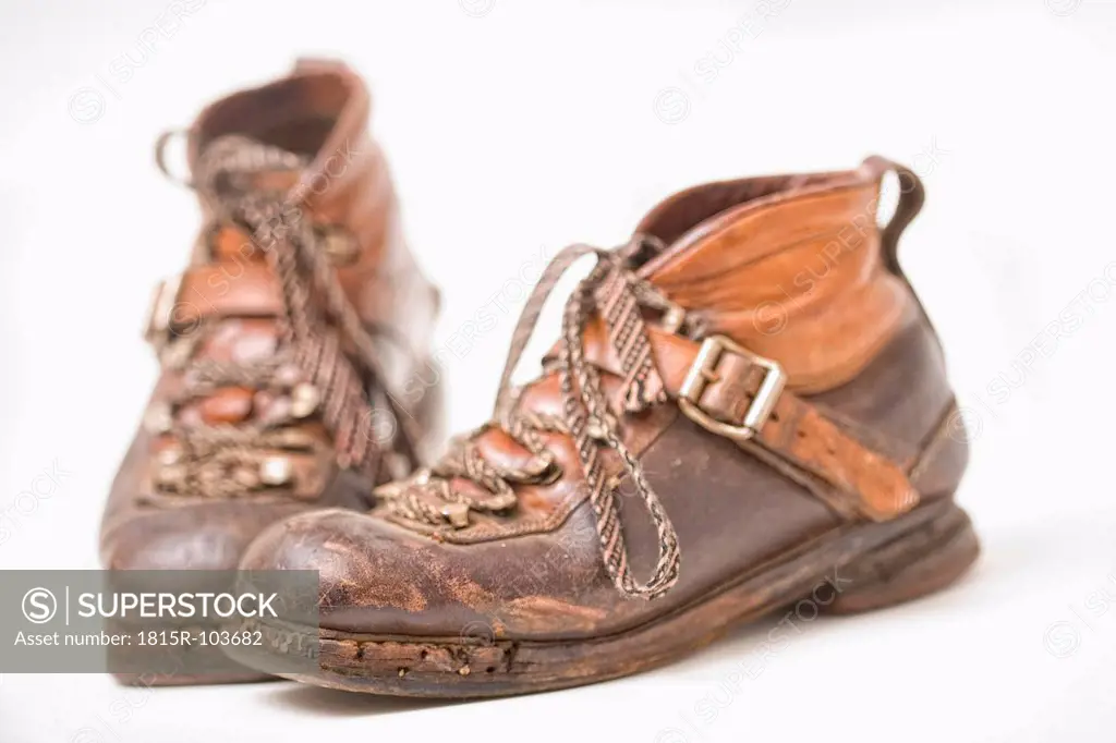 Old leather ski boots on white background