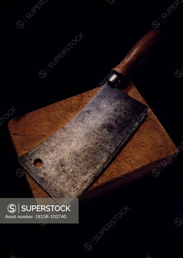 Butcher knife with chopping board on black background