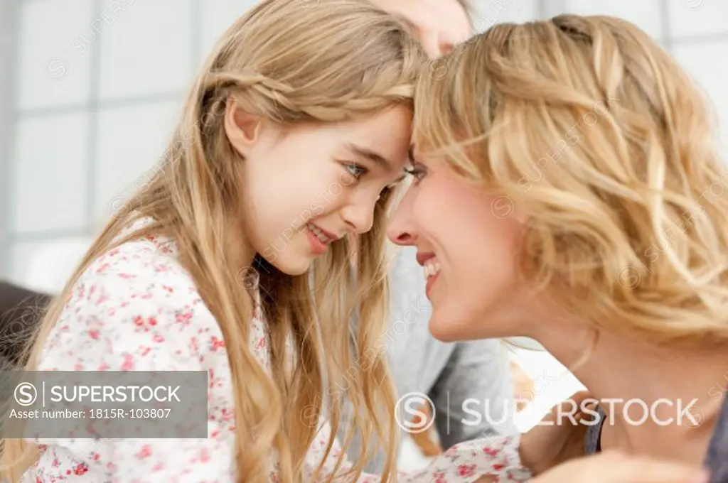 Germany, Leipzig, Mother and daughter looking at each other, smiling