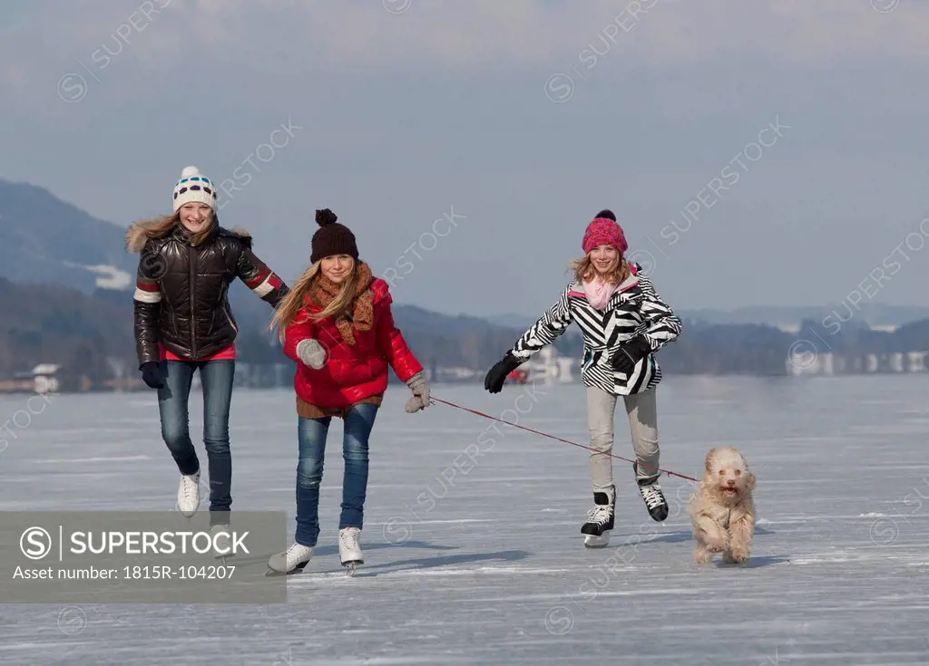 Austria, Teenage girls doing ice skating with dog