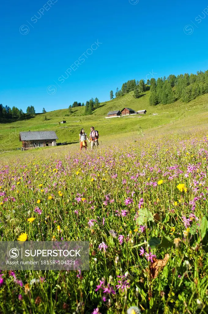 Austria, Salzburg, Couple walking through alpine meadow
