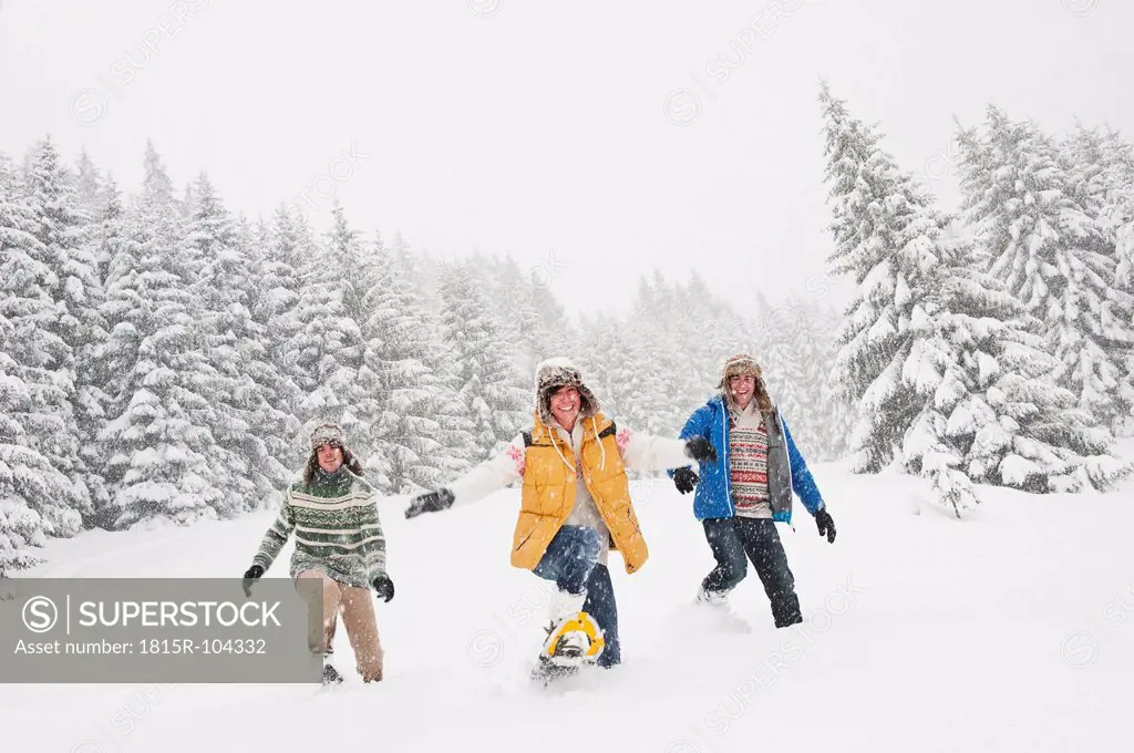 Austria, Salzburg, Men and woman walking through winter landscape