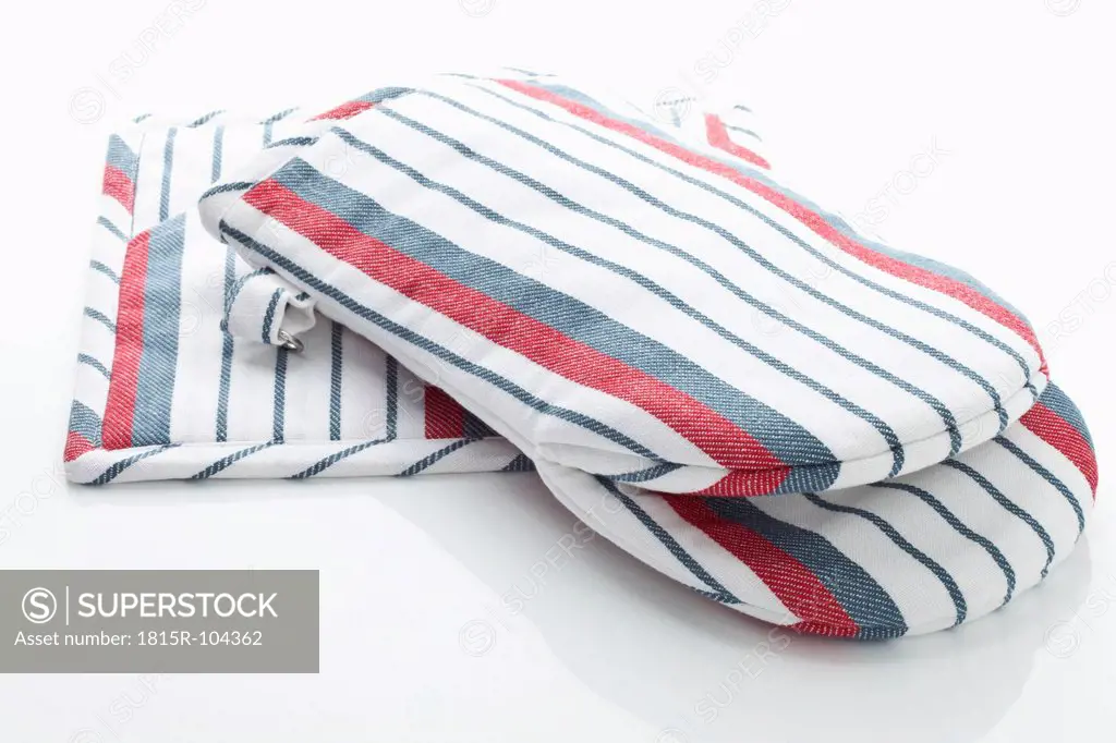 Striped oven glove and cloth on white background, close up