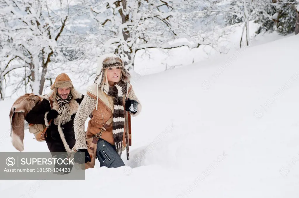 Austria, Salzburg County, Couple walking through winter landscape, smiling