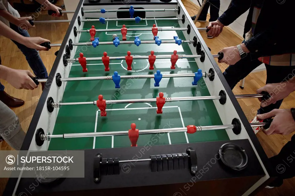 Germany, Cologne, Men and women playing table soccer