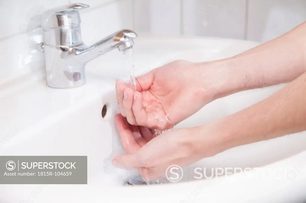 Young man washing hands, close up